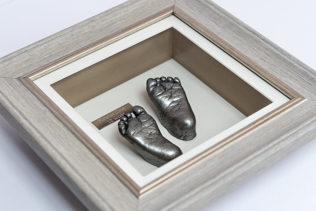 Bronze baby foot casting in 8x10 frame with photo